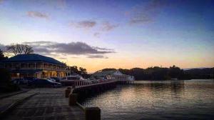 芒奥努伊Mangonui Hotel的停泊在水体旁边的一座建筑物