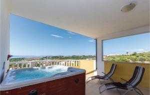 einen Whirlpool auf einem Balkon mit 2 Stühlen in der Unterkunft Amazing Apartment In Zrnovnica in Korešnica