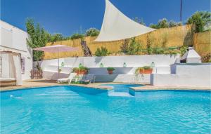 Una piscina con una sombrilla al lado de un edificio. en Stunning Home In Rute, en Zambra