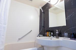 a white bathroom with a sink and a mirror at YOU STYLE HOTEL HAKATA in Fukuoka +15 photos