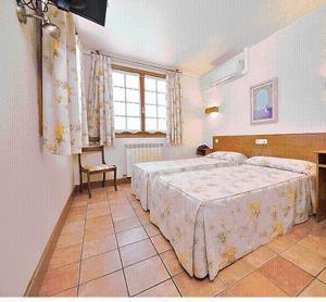 a large bedroom with two beds and a window at Hostal Lorentxo in Olave