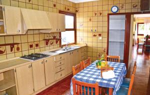 a kitchen with a table with a blue and white table cloth at 3 Bedroom Awesome Home In Porto Cristo in Porto Cristo