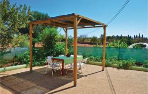 a wooden gazebo with a table and chairs at 3 Bedroom Awesome Home In Porto Cristo in Porto Cristo +16 photos
