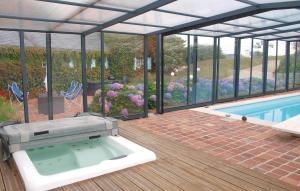 a hot tub on a deck next to a swimming pool at Awesome Home In Saint Pabu With Sauna in Saint-Pabu