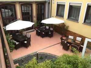 een patio met tafels, stoelen en parasols bij Gasthaus Breitenbach in Bad Brückenau