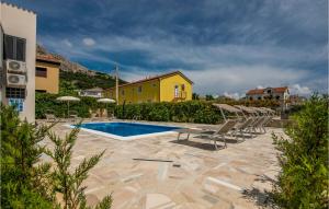 a swimming pool with lounge chairs and a yellow house at Stunning Home In Jurandvor With Outdoor Swimming Pool in Jurandvor