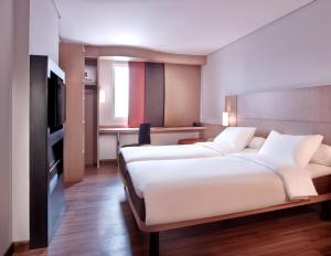 سرير أو أسرّة في غرفة في Ibis Gading Serpong