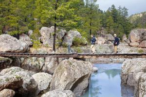 a group of people standing on a bridge over a river at Bosques in Creel