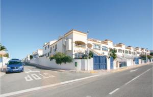 聖波拉的住宿－Amazing Apartment In Gran Alacant With Outdoor Swimming Pool，停在一排房子前面的一辆蓝色汽车