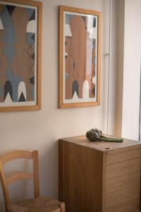 einen Tisch mit einem Stuhl und zwei Bilder an der Wand in der Unterkunft City Centre Studios in Limassol