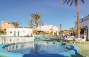 uma piscina num resort com palmeiras e cadeiras em Lovely Home In Torrevieja With Kitchen em Torrevieja