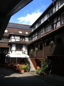 a building with a table and an umbrella in front of it at Hotel Ochsen Kehl-Kork in Kehl am Rhein