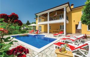 a villa with a swimming pool and patio furniture at 4 Bedroom Beautiful Home In Kranjci in Raša