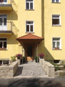 a yellow building with a door and a porch at Sanderau NA29 in Würzburg