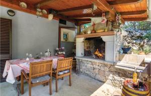 a dining room with a table and a fireplace at Stunning Home In Opatija With 2 Bedrooms, Wifi And Outdoor Swimming Pool in Marčelji