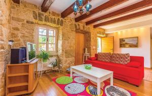 a living room with a red couch and a tv at Lovely Home In Garica With Wifi in Garica