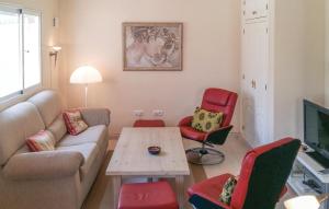 オリフエラ・コスタにあるNice Home In Orihuela Costa With Outdoor Swimming Poolのリビングルーム(ソファ、赤い椅子付)