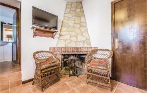 ein Wohnzimmer mit 2 Stühlen und einem Kamin in der Unterkunft 6 Bedroom Gorgeous Home In Riudoms in Riudoms