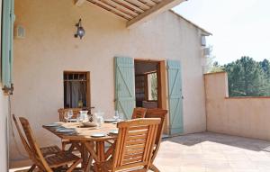 a wooden table and chairs on a patio at Beautiful Home In Montauroux, Var With Private Swimming Pool, Can Be Inside Or Outside in Montauroux