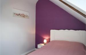 ein Schlafzimmer mit einem Bett mit einer lila Wand in der Unterkunft Awesome Home In Le Cambout With Wifi in Le Cambout