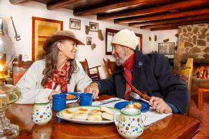 a man and woman sitting at a table with a plate of food at Bosques in Creel