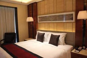 a bedroom with a white bed with a window at Crowne Plaza Sanya City Center, an IHG Hotel in Sanya