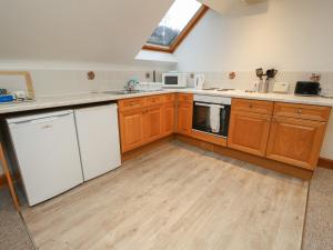 a kitchen with wooden cabinets and white appliances at Bruce in Pitlochry +13 photos