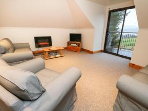 een woonkamer met 2 banken en een tv bij Bruce in Pitlochry