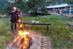 two people standing next to a camp fire at Bosques in Creel