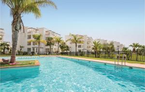 uma piscina com palmeiras e edifícios em 2 Bedroom Cozy Apartment In Roldn em Roldán