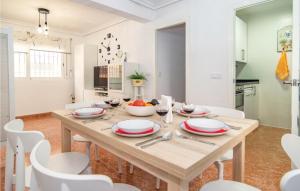 uma sala de jantar com uma mesa de madeira e cadeiras brancas em Stunning Apartment In Crdoba With 2 Bedrooms And Wifi em Córdoba