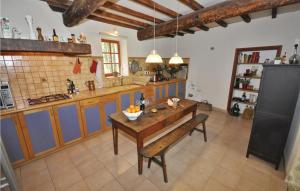 cocina grande con mesa de madera y armarios azules en Amazing Home In Murviel-ls-bziers With Outdoor Swimming Pool, en Murviel
