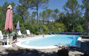 una piscina en un patio con sombrilla y sillas en Gorgeous Apartment In Lorgues With Kitchen, en Lorgues