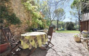 a table and chairs with a yellow and white table cloth at 1 Bedroom Amazing Apartment In Lorgues in Lorgues