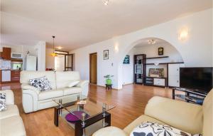 ein Wohnzimmer mit einem weißen Sofa und einem Fernseher in der Unterkunft Amazing Home In Icici in Ičići