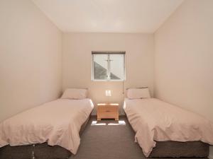 En eller flere senger på et rom på Golfer's Paradise - Matarangi Holiday Home