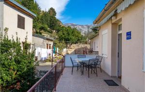 a patio with a table and chairs on a balcony at Beautiful Apartment In Jablanac With Wifi in Jablanac