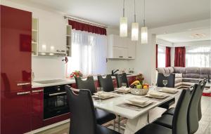 a kitchen and dining room with a table and chairs at Amazing Apartment In Krk With Outdoor Swimming Pool in Vrh