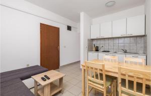 eine Küche und ein Esszimmer mit einem Holztisch und Stühlen in der Unterkunft Amazing Apartment In Prizna With 3 Bedrooms And Wifi in Prizna