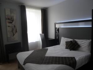 a bedroom with a large bed with a large window at Auberge bretonne in Châteaubriant