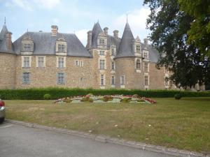 a large brick building with a garden in front of it at Auberge bretonne in Châteaubriant
