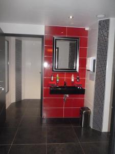 a red bathroom with a sink and a mirror at Auberge bretonne in Châteaubriant +24 photos