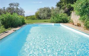 Una piscina con agua azul en un patio. en Cozy Home In Valreas With Wifi, en Valréas