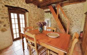 une table en bois avec des chaises et un vase de fleurs. dans l'établissement Awesome Home In Valreas With Outdoor Swimming Pool, à Valréas