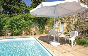 un patio con sombrilla, 2 sillas y una piscina en Cozy Home In Valreas With Wifi, en Valréas