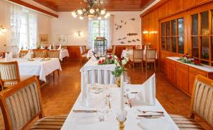 un comedor con mesas y sillas blancas en Hotel Landgasthof Schönbühl, en Schönbühl