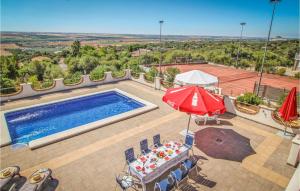 an overhead view of a swimming pool with an umbrella and chairs at Awesome Home In Almodvar Del Ro With 5 Bedrooms, Wifi And Outdoor Swimming Pool in Almodóvar del Río