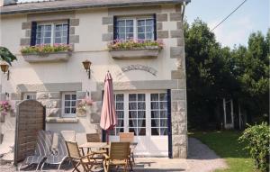 LʼIsle-Saint-CastにあるStunning Home In Saint Cast Le Guildo With Kitchenのテーブルと椅子と傘が備わる家