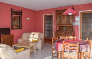 LʼIsle-Saint-CastにあるStunning Home In Saint Cast Le Guildo With Kitchenの赤い壁のリビングルーム(テーブル、椅子付)
