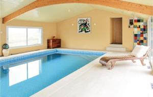 a swimming pool in a room with a bench and a chair at Beautiful Home In Plouarzel With Indoor Swimming Pool in Rubian